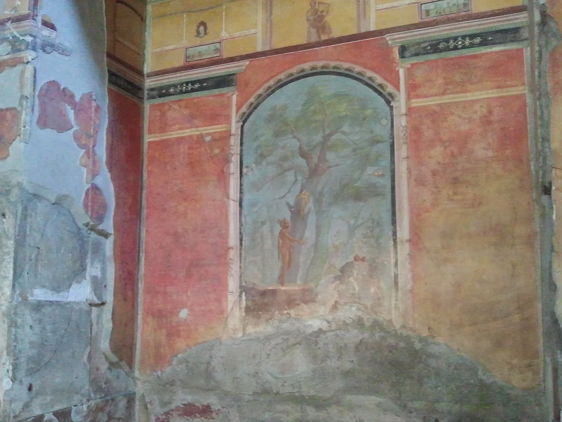 Un affresco con un giardino dipinto sulle pareti rosse della Villa di Poppea a Oplontis