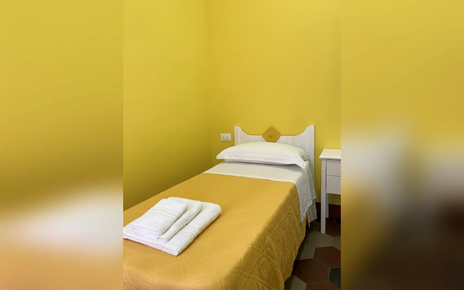 La Camera Limone del Vesuvio con il letto singolo e il copriletto giallo