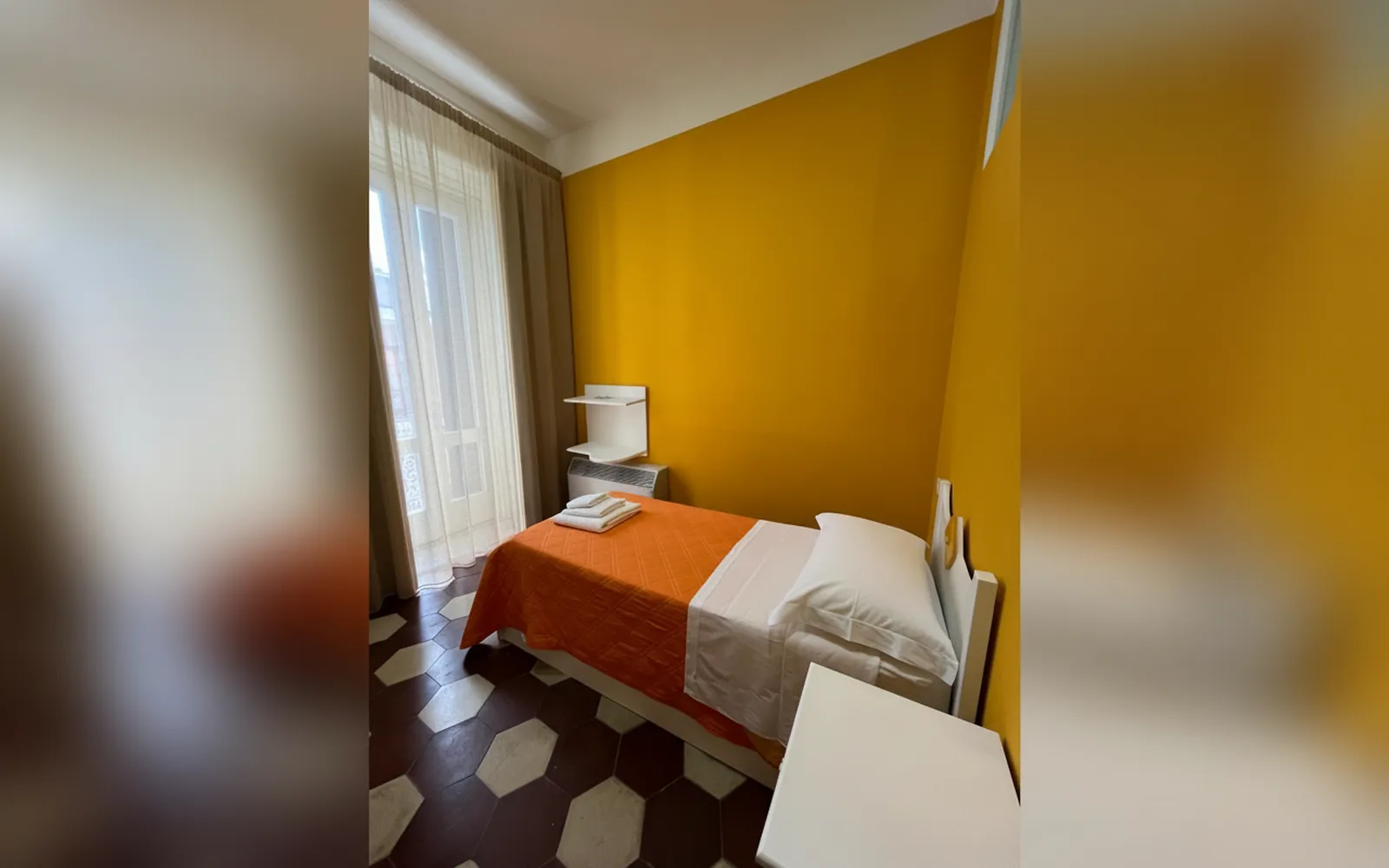 Il letto con il copriletto arancione nella Camera Arancia del Vesuvio